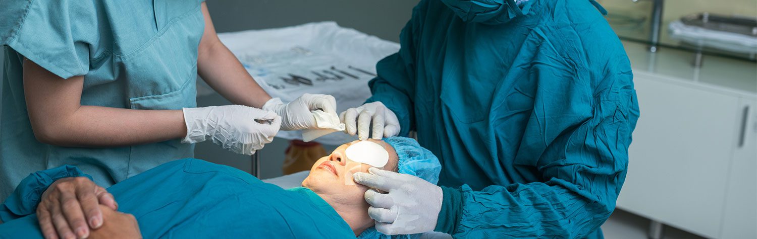 Surgeon and assistant applying medical match on eye of patient