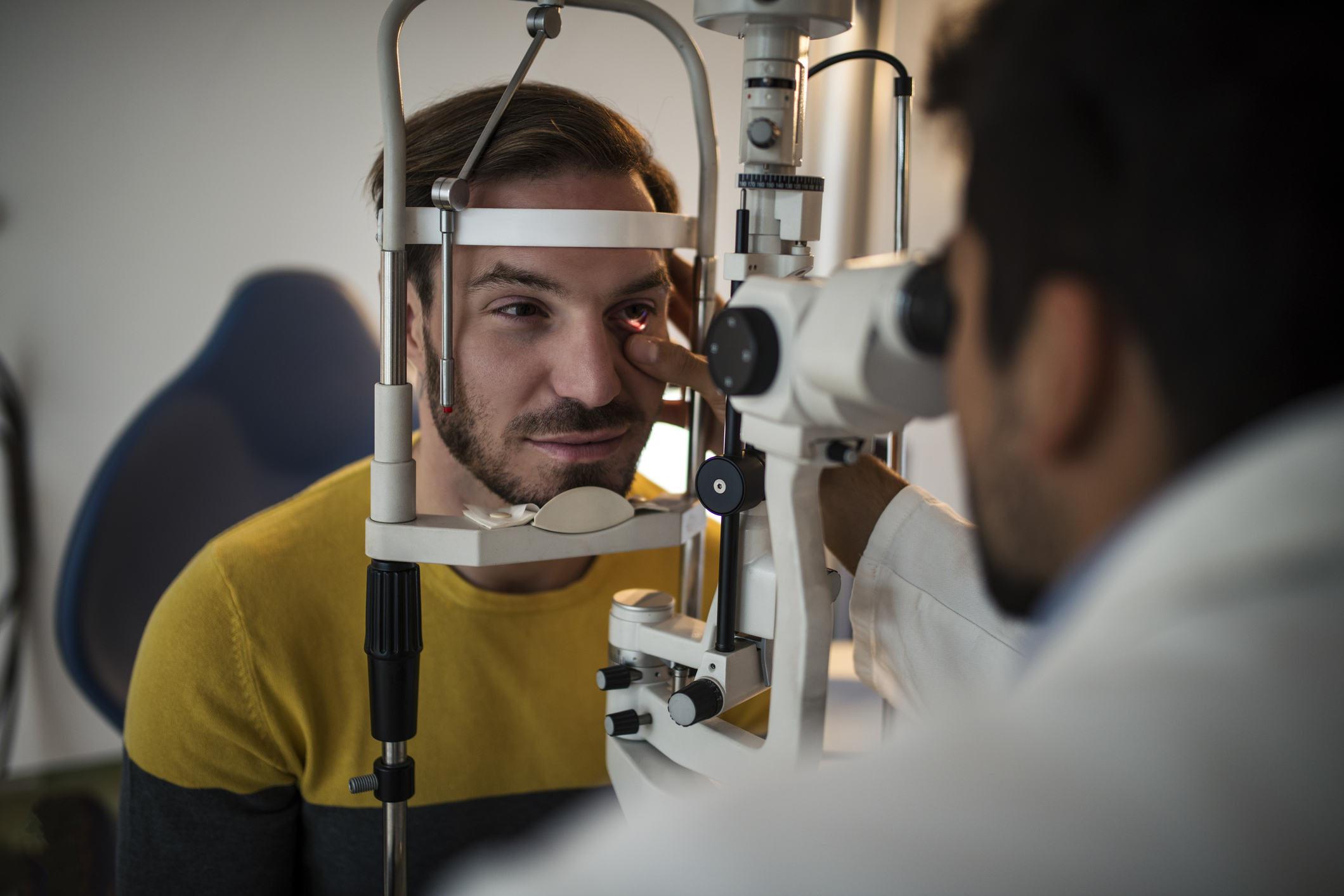 A man receiving an eye exam from a doctor.