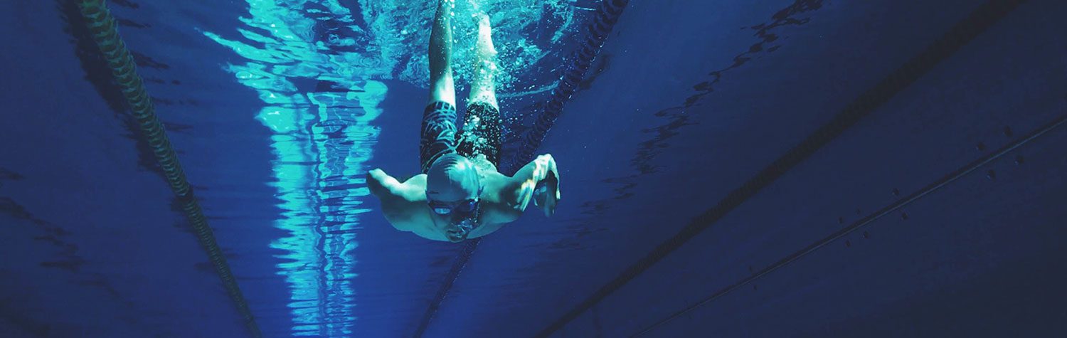 A man in goggles swimming underwater.