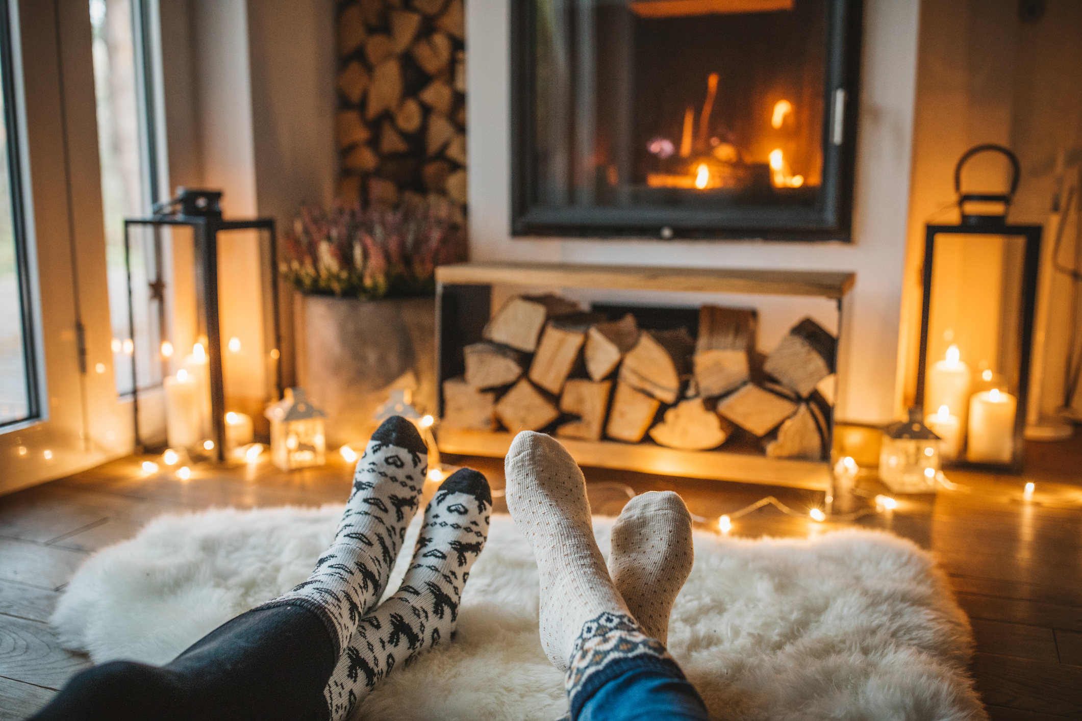 Two people propping their feet up in front of a fire