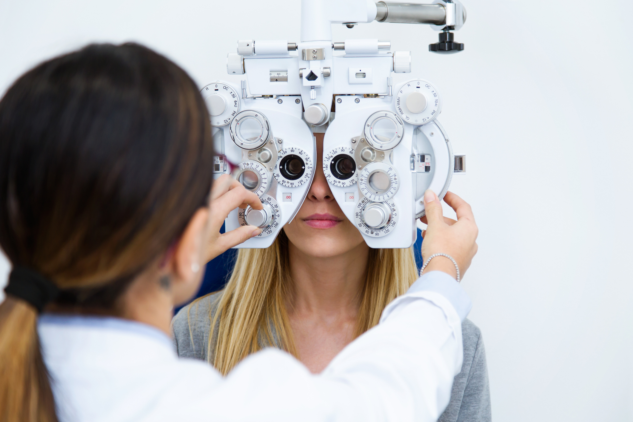 A doctor performing an eye exam on a woman