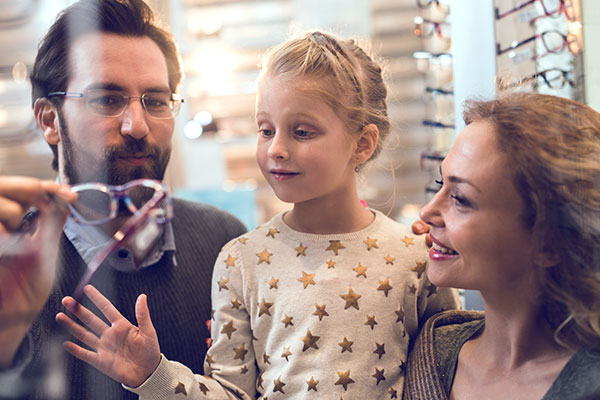 A family selecting eyeglasses for their daughter.