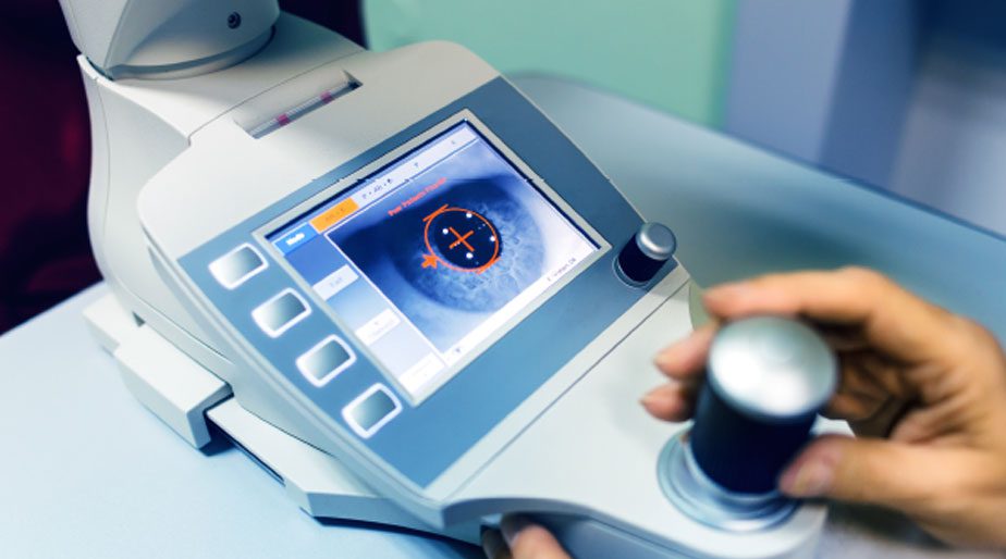 A doctor examining an eye through the camera of a medical device