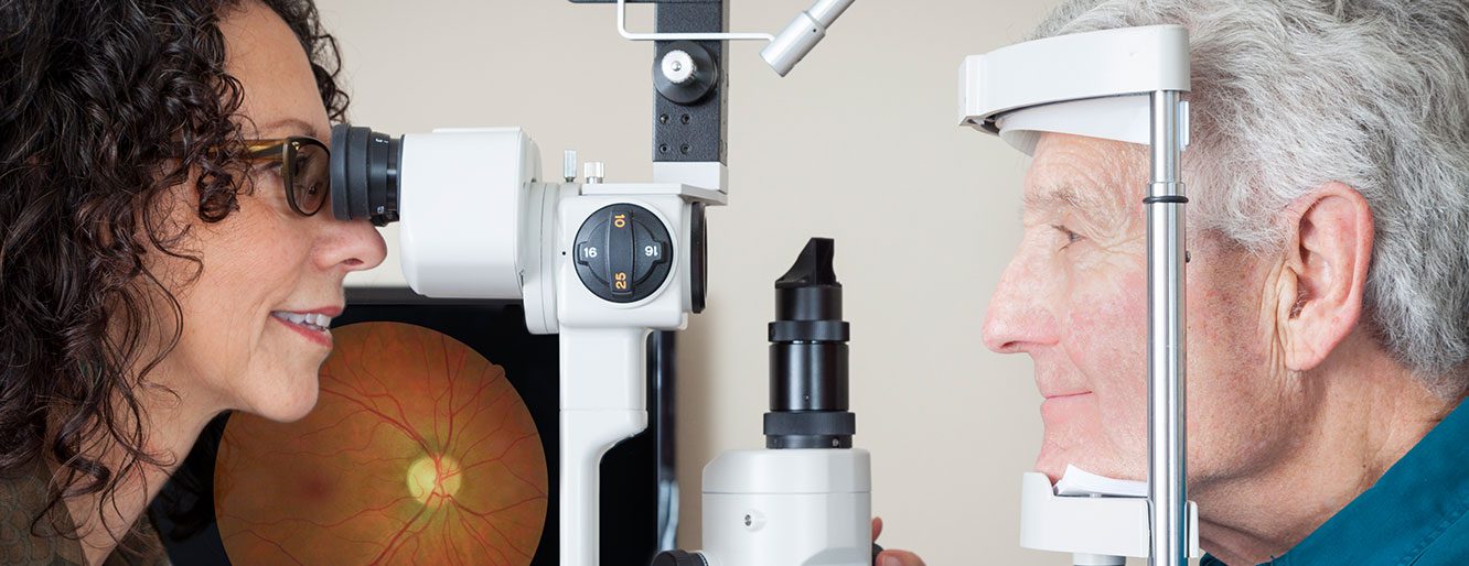 An older patient's eyes being examined by a doctor