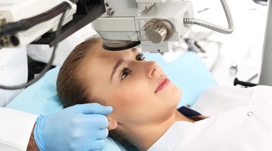 A woman laying down and having her eyes examined.