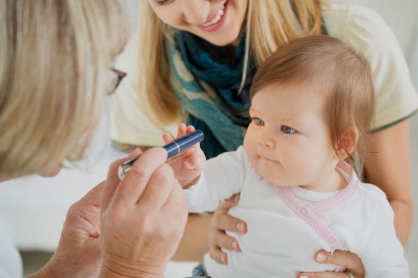 A baby having their eye's examined by a doctor.