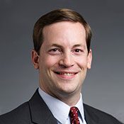 Vistar Eye Center Doctor Stuart Tims smiling in front of a gray background