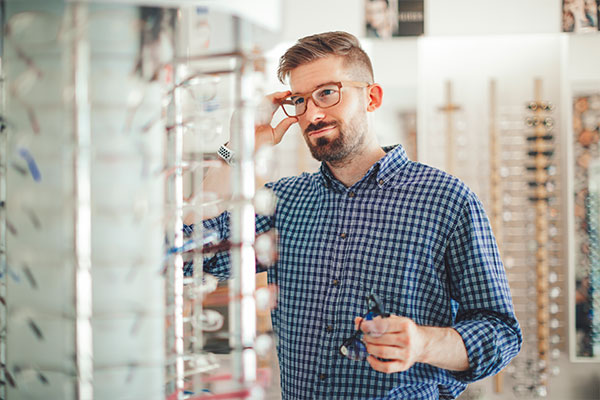 A man trying out eyeglasses before purchasing a pair