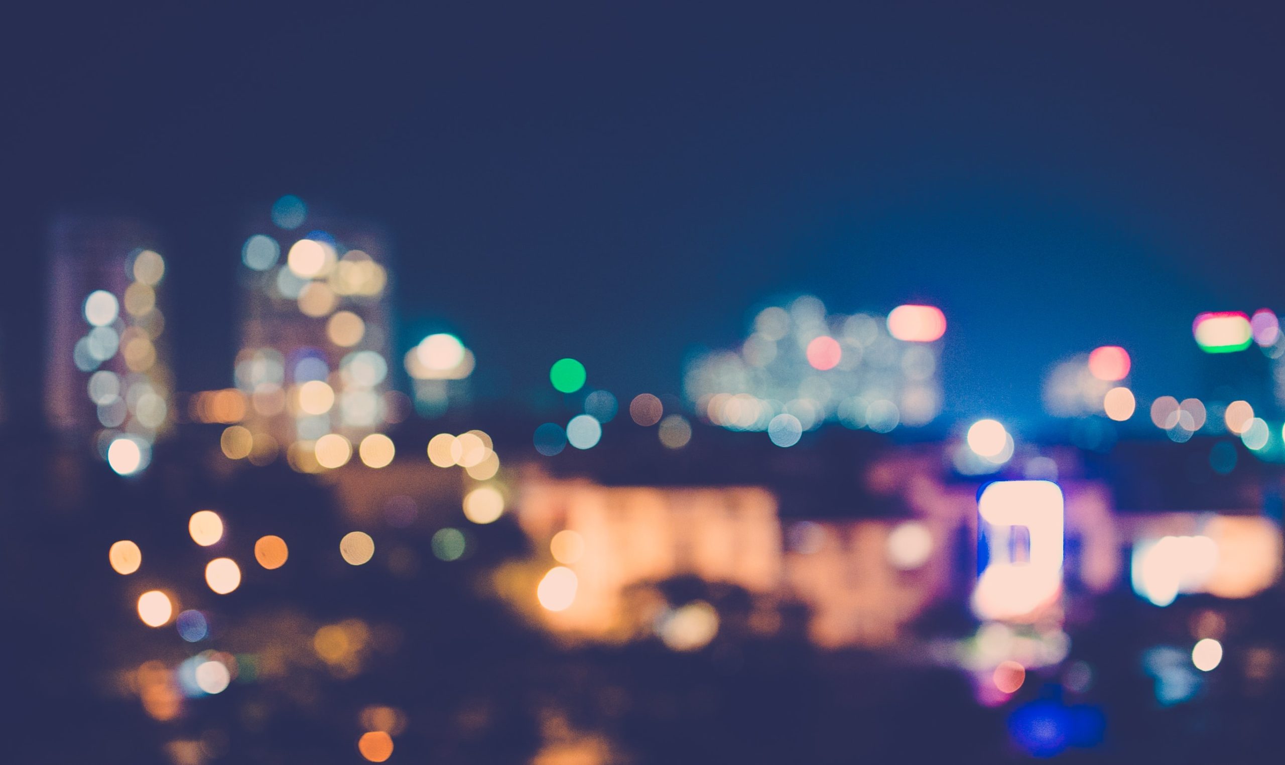 A blurred view of a city skyline at night.