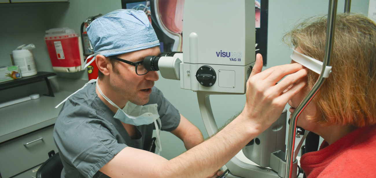 An eye doctor examining a patient using a optical device