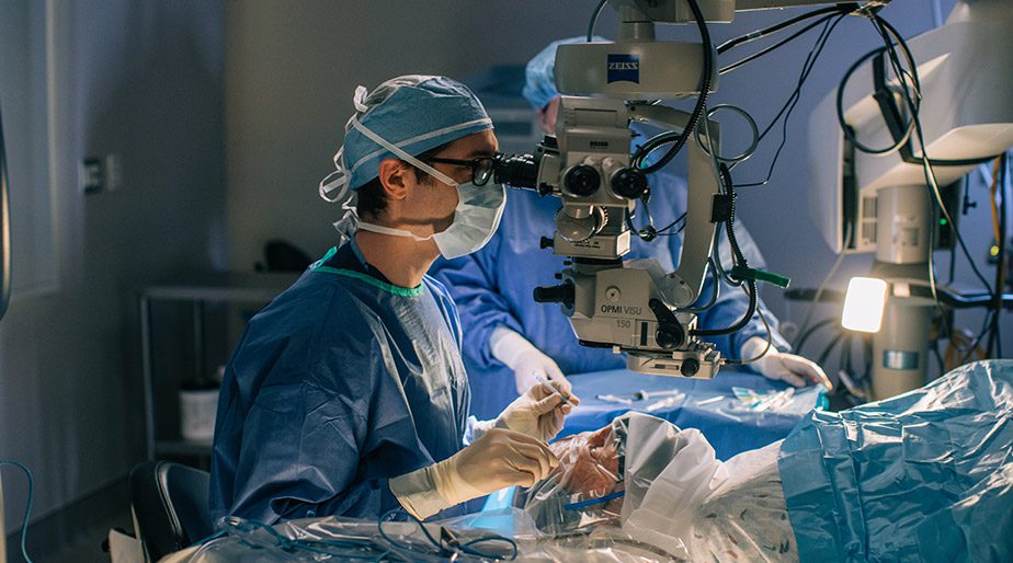 Dr. Schoedel looking through a medical device during a patient procedure.