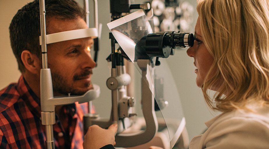 Dr. Andrews with a patient using a eye procedure device.