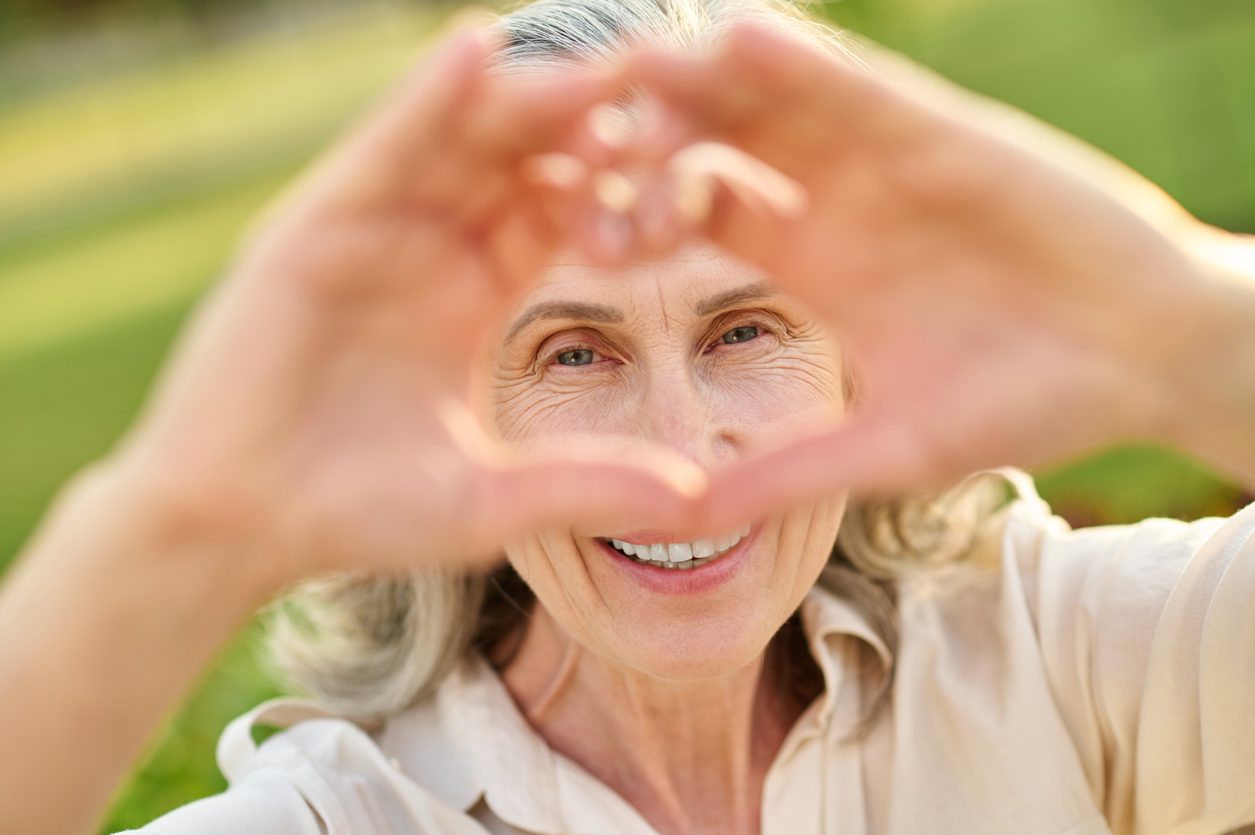 woman makes a heart with her hands