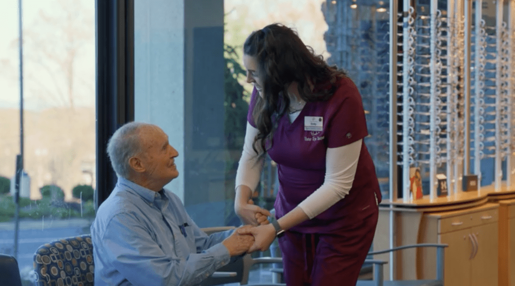 A smiling Vistar employee helping an elderly patient in the waiting room